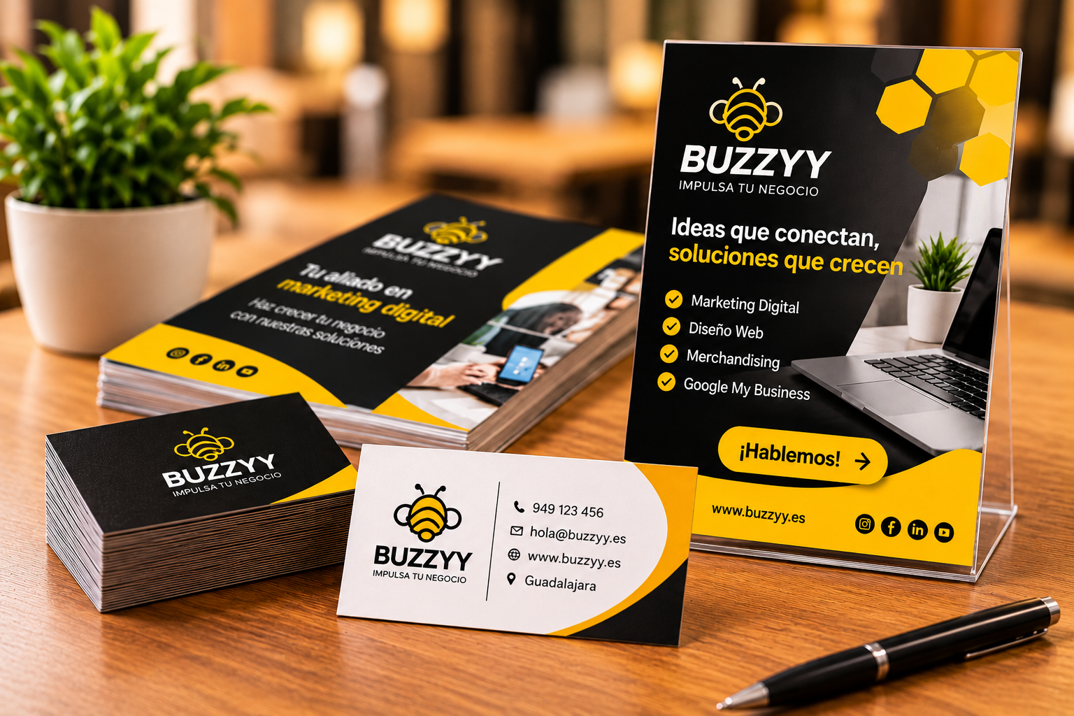 Material promocional personalizado de BUZZYY con tarjetas de visita, folletos publicitarios y productos corporativos en amarillo y negro